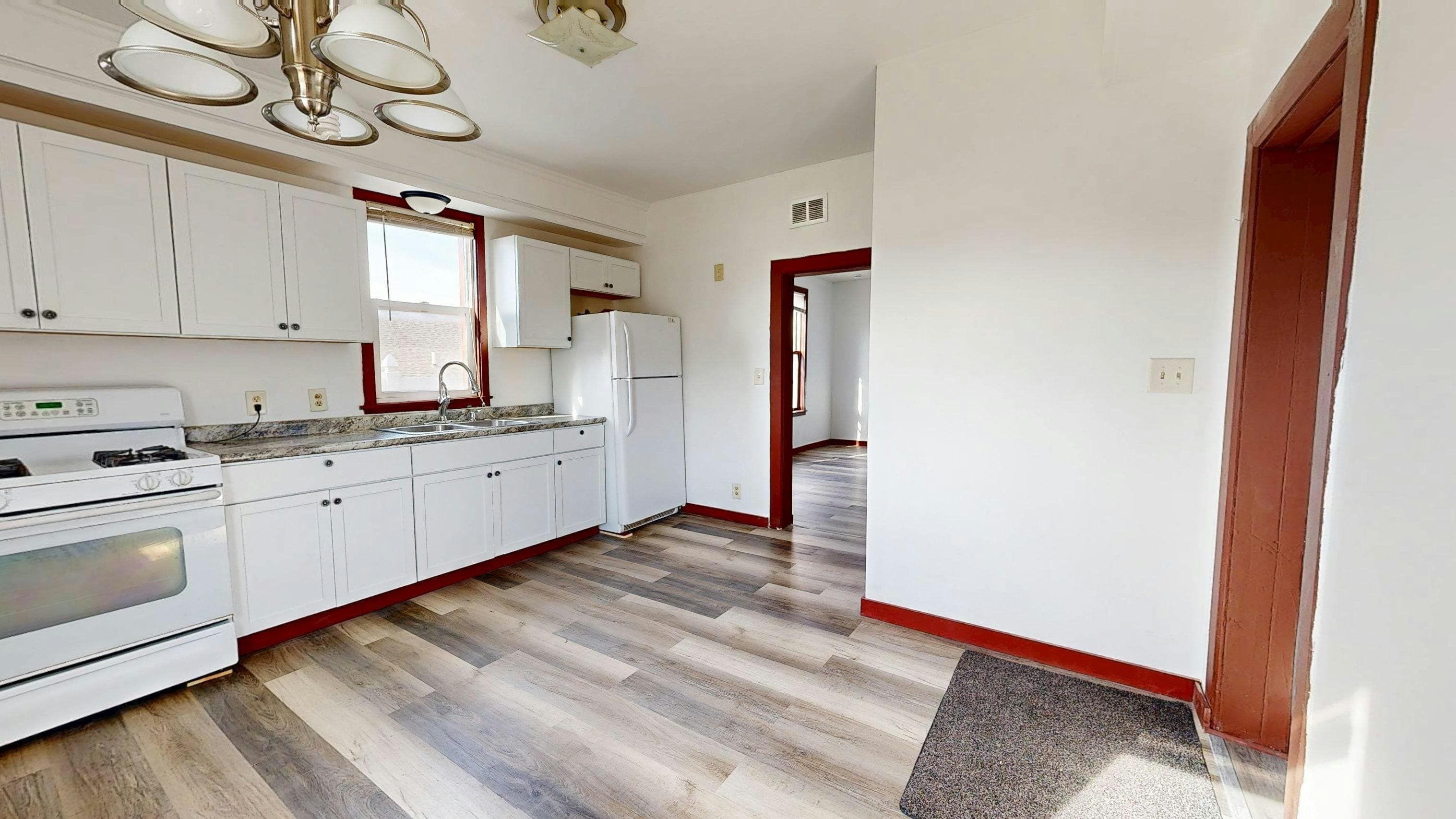 Dated kitchen with white cabinets and red trim before renovation